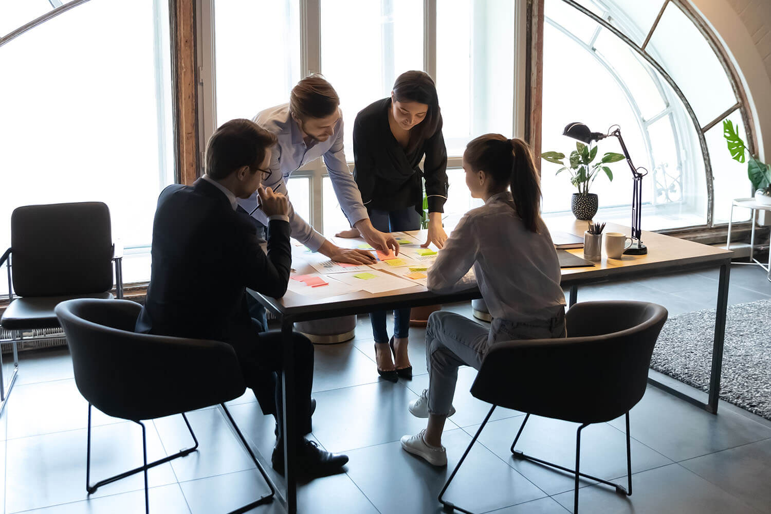 Four employees working together at a desk