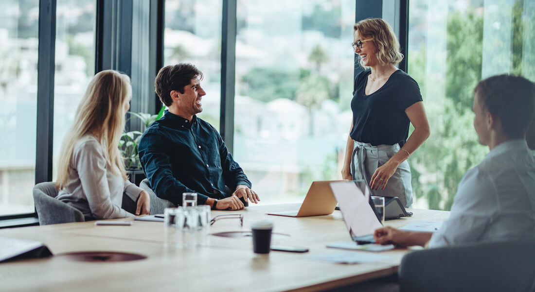 Happy coworkers discussing corporate social responsibility