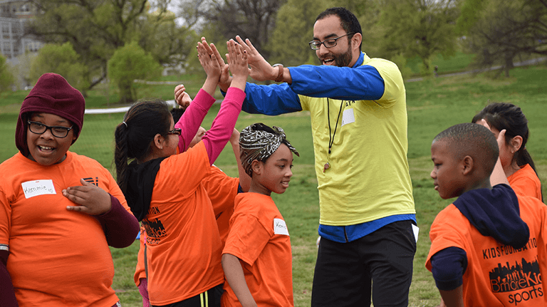 Youth soccer coach giving one of the players a high five