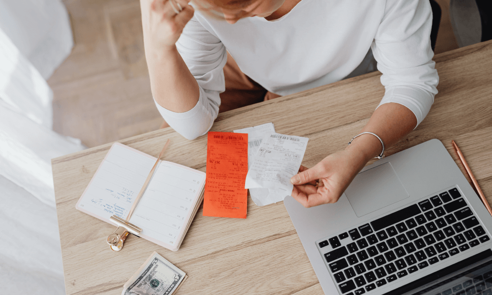 Woman sitting behind her desk looking at receipts